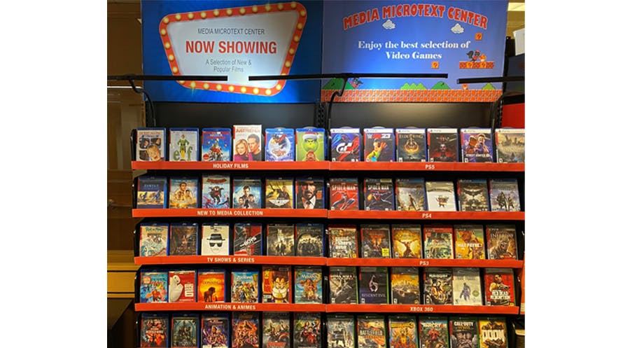 Two Media Microtext Center wall displays side by side, one showing video covers, the other showing video game covers.