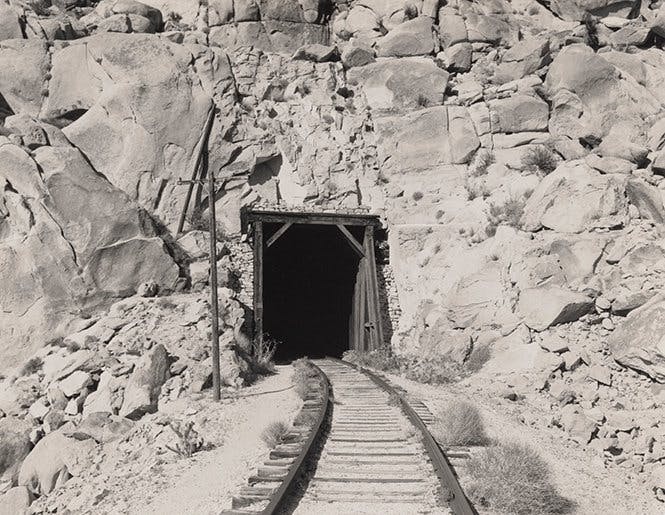 railroad tracks leading to a tunnel