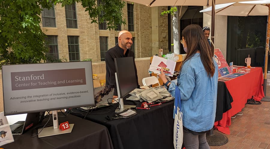 Two people who are standing and interacting at the JEDI Fair tabling event