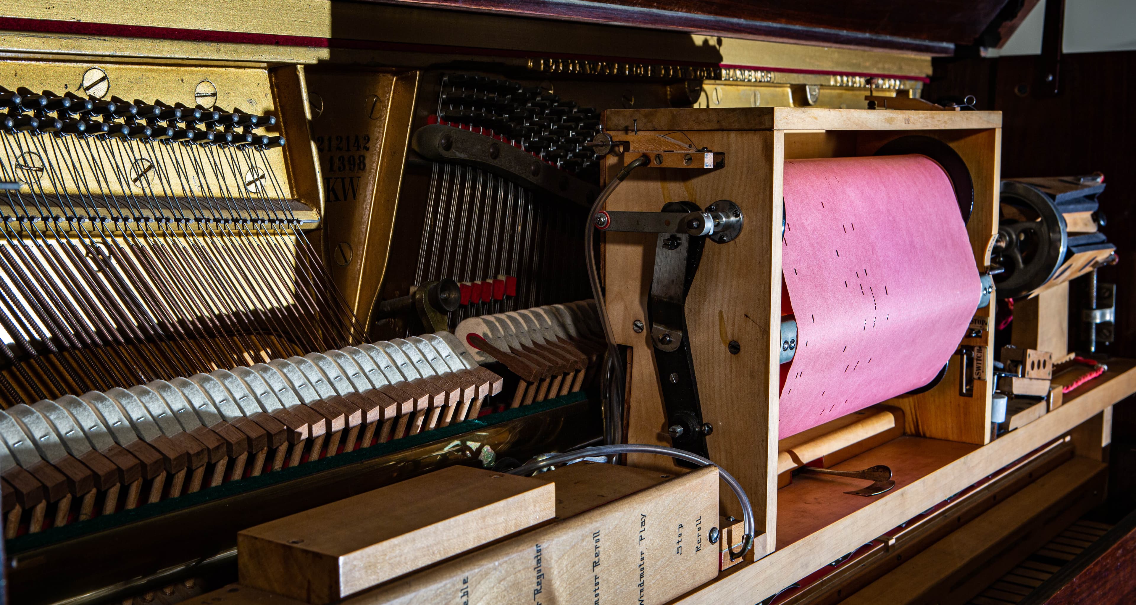 Close up view of the interior of a player piano including the paper piano roll.