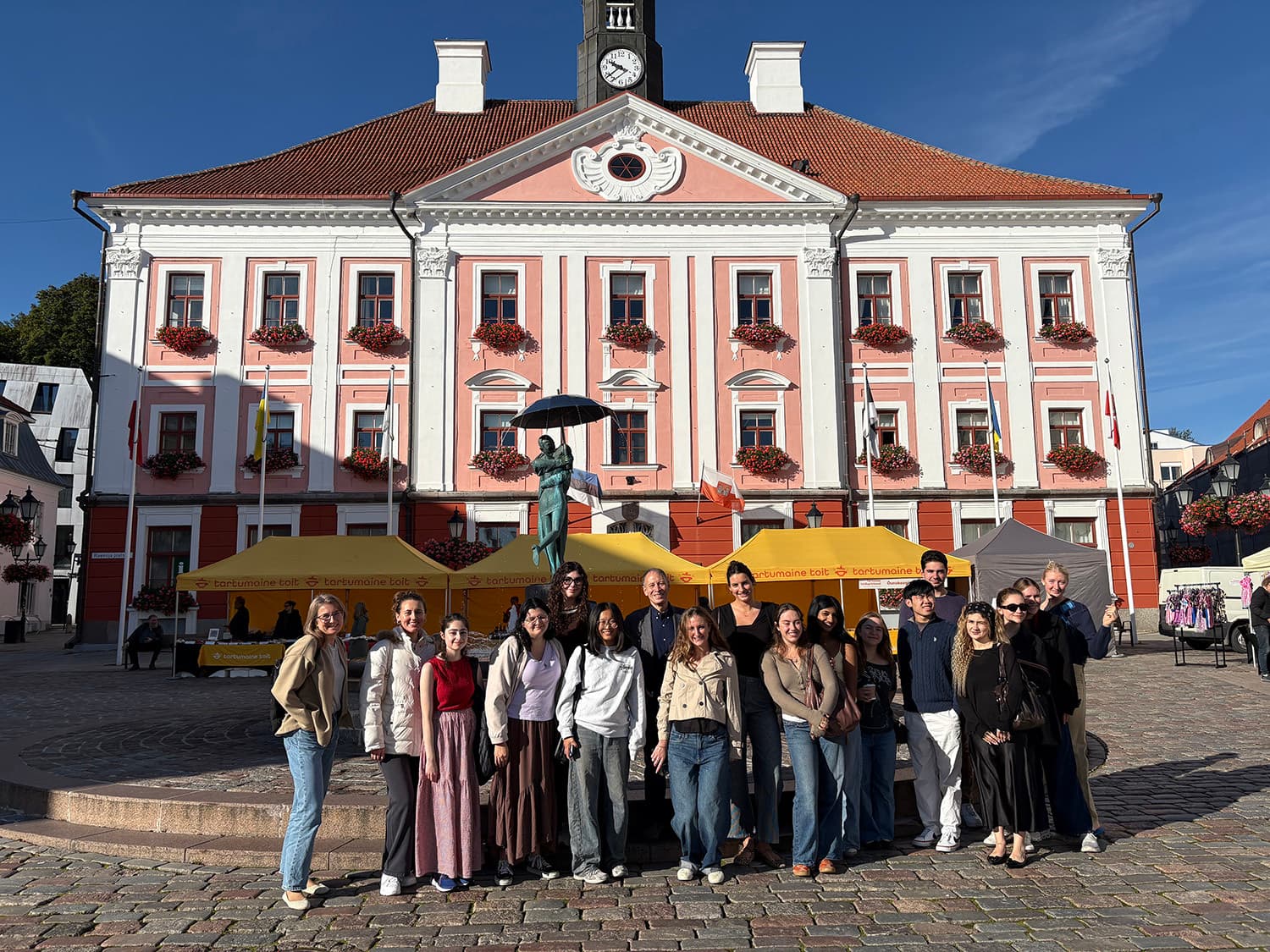 Group of students posing in front of a pink three-story building in Tartu, Estonia.