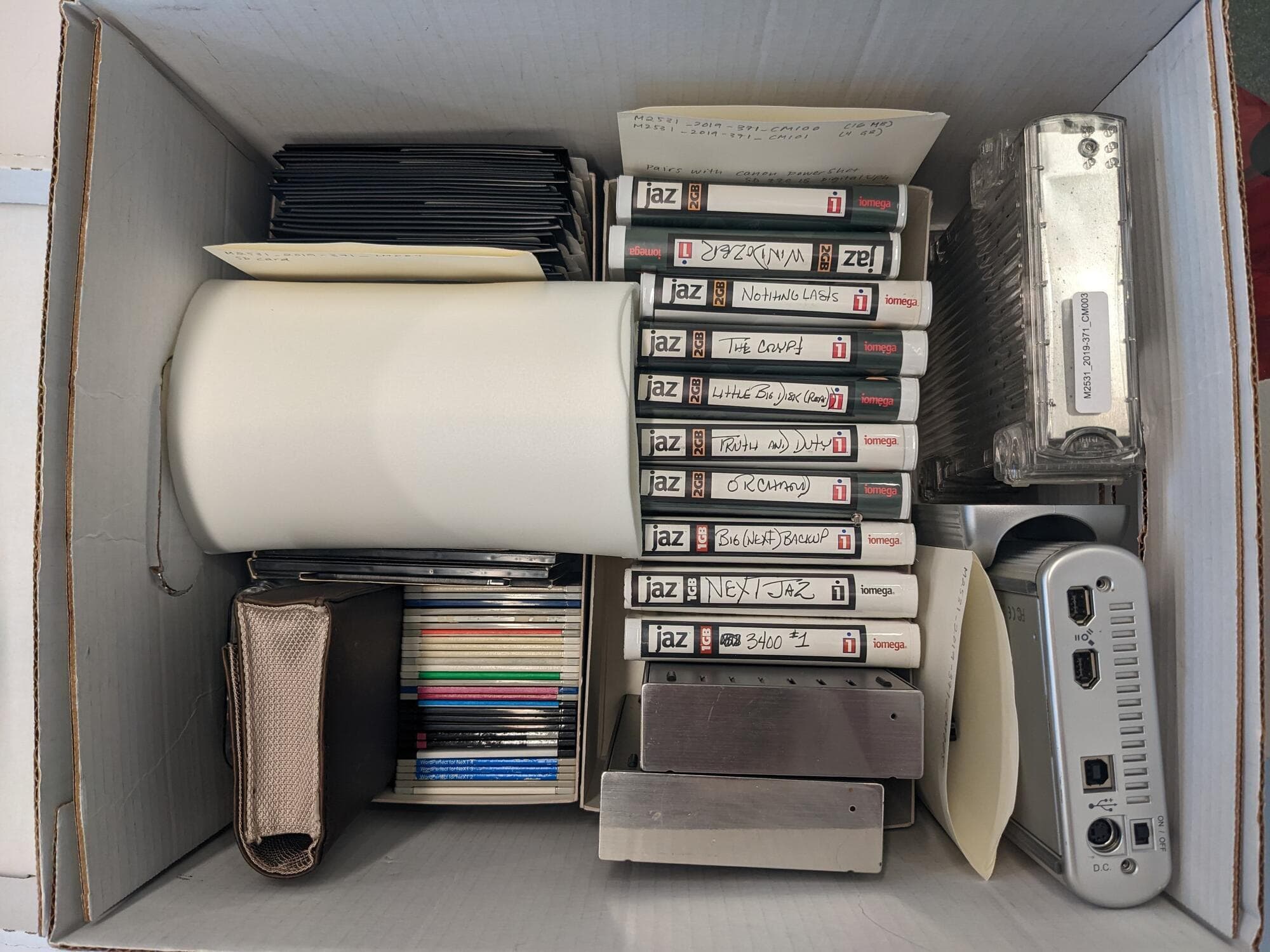 Various types of physical computer media in a box.