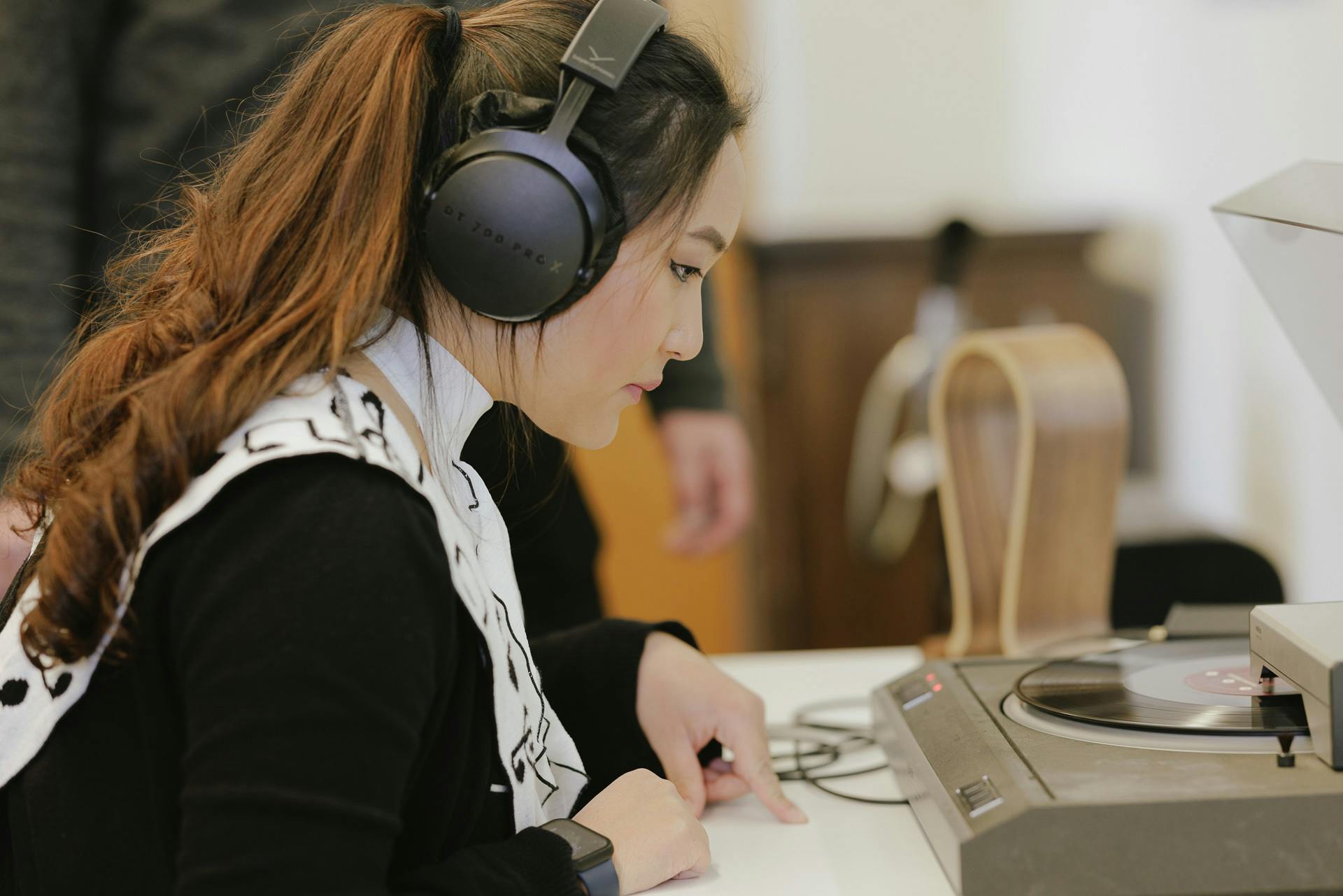 Student with earphones listening to music playing on a record player