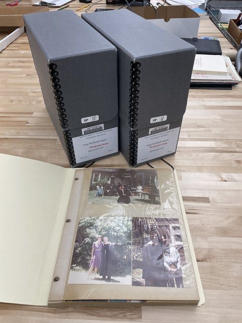 Two archival boxes with photo album showing pictures of Jorge Ruffinelli.